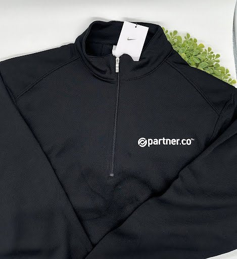 A black zip-up Nike jacket with the 'partner.co' logo on the chest, displayed on a mannequin.